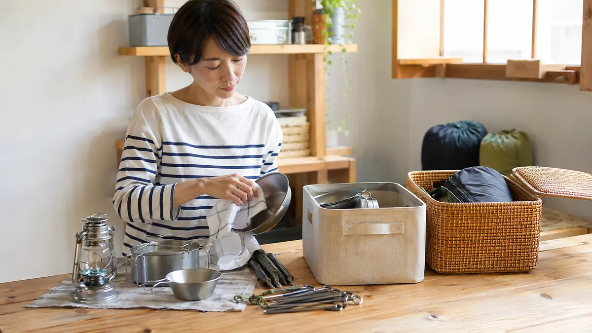 キャンプ用品を収納する前のお手入れ キャンプ用品を乾燥させてから収納する日本人女性
