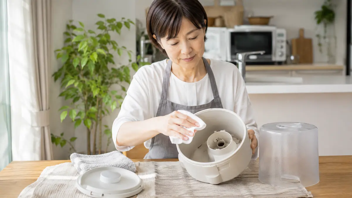 収納前に加湿器を掃除する方法 加湿器の収納前にタンクと本体内部を掃除する日本人女性