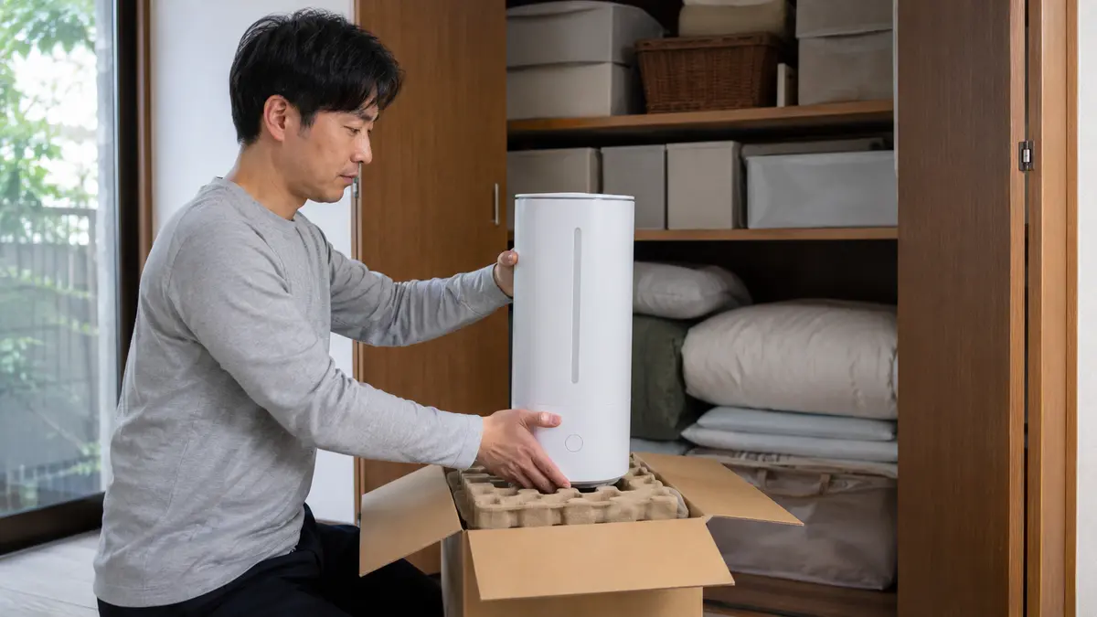 加湿器を箱に入れて立てて保管 加湿器の収納アイデアとして購入時の箱へ立てて入れる男性