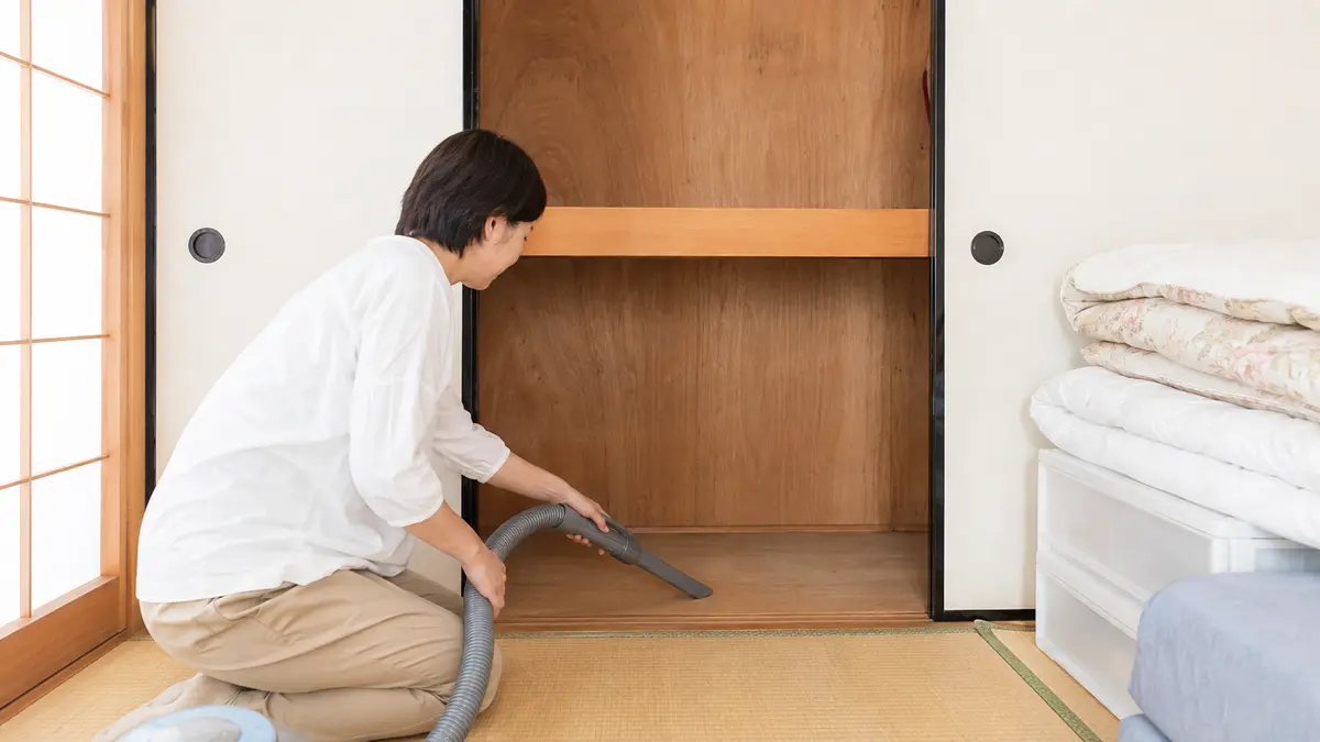 押し入れを空にして行う虫対策の掃除 収納物を出して押し入れの隅に掃除機をかける虫対策